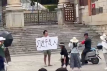 Một người ở Côn Minh cầm biểu ngữ “Tập Cận Bình đi xuống” thu hút sự chú ý